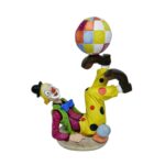 Palhaço vintage em resina, deitado no chão com os pés para cima segurando uma bola colorida. Disponível para locação para festa no tema circo.