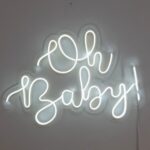 Luminoso em LED neon escrito "Oh Baby!" para chá de bebê, em letra cursiva, na cor branco claro.